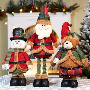 Three telescoping Christmas plush dolls including Santa and Snowman in a festive home setting