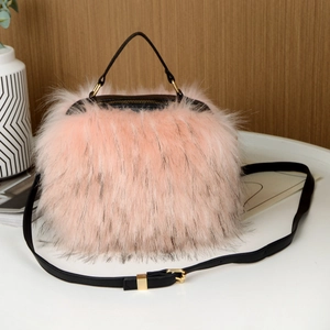 Detail of pink faux fur crossbody bag with black handle and gold-tone metal hardware