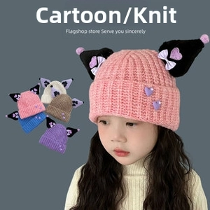 Close-up of knitted kid's beanie featuring cartoon character ears and bow details