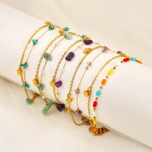 Detail of 18k gold plated twist chain anklet featuring bohemian style gemstones and heart charms