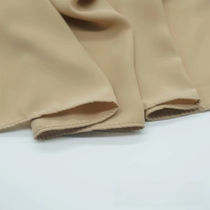 Close-up of khaki pleated satin chiffon fabric showing smooth texture and edge stitching