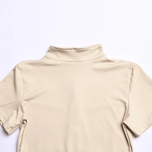 Detail of beige bodysuit featuring a sleek half-high collar and soft elastic fabric