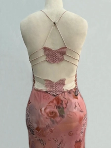 Close-up of pink mesh dress back featuring delicate lace butterfly appliques and thin straps