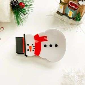 Close-up of Christmas snowman hair claw clip made of glossy acetate with festive decorations