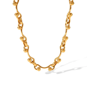 Detail of gold horseshoe buckle chain necklace with polished metal rods and spherical beads