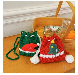 Detailed knit of Christmas reindeer drawstring bags with festive ornaments on wood