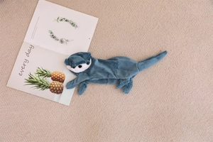 Detailed view of a soft blue plush otter pencil case with cute animal features on a rug