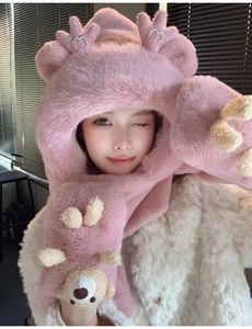 Détail d'une écharpe à capuche en peluche rose avec oreilles d'ours et broderie