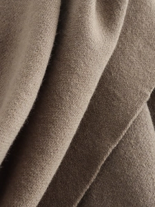 Detailed macro view of soft camel knit fabric texture and high-quality wool fibers