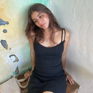 Sexy black cotton dress with lace V-neck and open back design on a sitting model