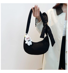 Détail du sac croissant noir avec bandoulière à nœud et pendentif lapin blanc