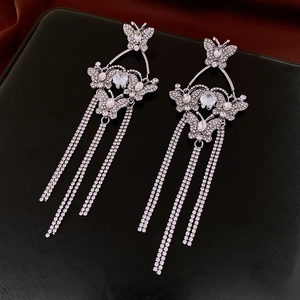 Detailed close-up of bow tassel drop earrings with sparkling rhinestones and silver finish