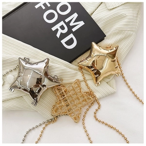 Detailed view of glossy star-shaped mini bags in gold and silver with ball chain straps
