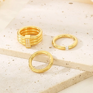 Detailed view of 18k gold plated titanium rings with zircon inlay on stone surface