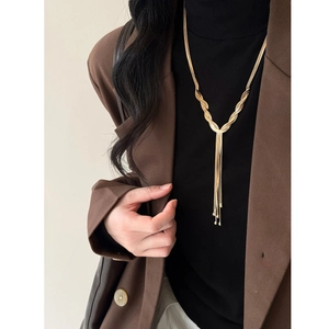 Close-up of golden multi-layered fringe necklace with intricate woven metal texture