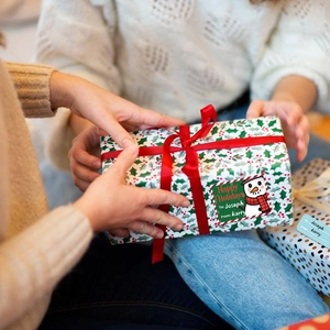 Detail showing a Christmas gift label with snowman and To/From fields on a gift box