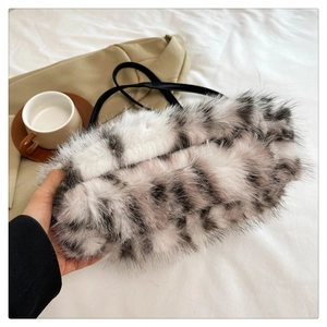 Close-up of black and white spotted plush handbag with premium faux fur texture
