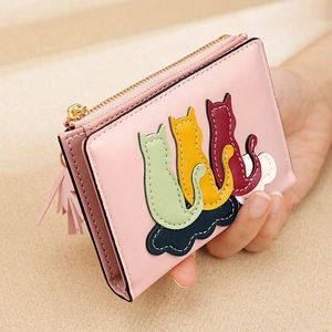 Close-up of pink short wallet with cute colorful cat silhouette embroidery and tassel