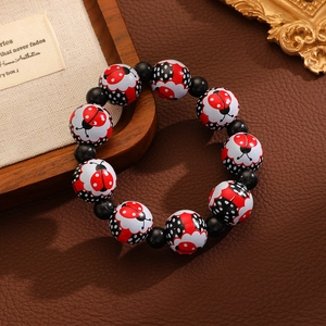 Détail d'un bracelet coccinelle avec perles noires sur fond de cuir vintage élégant