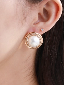 Close-up of rose gold pearl hoop earrings with zircon accents on ear for elegant styling