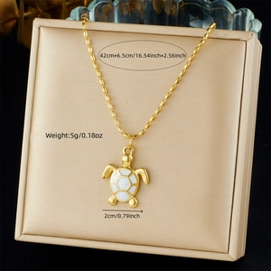 Close-up of golden sea turtle pendant with white enamel on 42cm bead chain necklace