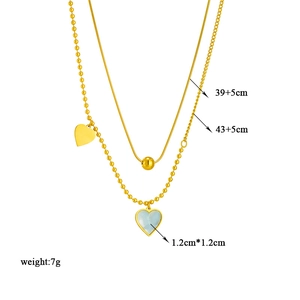 Double-layered gold necklace with heart shell pendant, bead chain, and snake chain layers