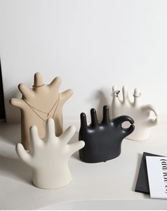 Detail of minimalist ceramic hand jewelry organizers in four colors for ring and necklace storage