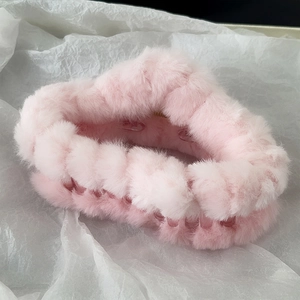 Close-up of large pink plush hair claw clip with soft faux fur texture for thick hair