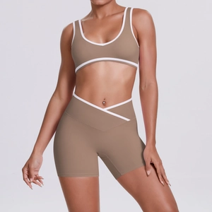 Detail of cross-waist yoga shorts and U-neck sports bra in brown with white trim