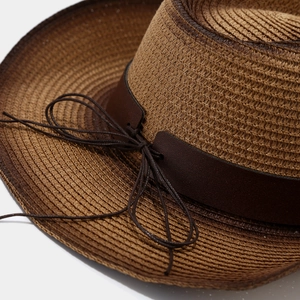 Detailed close-up of brown gradient straw weave hat with leather band and cord knot