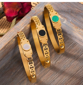 Detailed view of three vintage gold titanium bracelets with shell and acrylic inlays