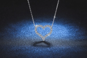 Macro shot of silver heart-shaped moissanite pendant featuring detailed pavé settings