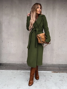 Dark green wool coat with a belted waist and lapel collar in a full-length outdoor shot