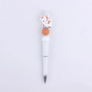 Detail of creative cartoon cow silicone bead on a white DIY plastic ballpoint pen