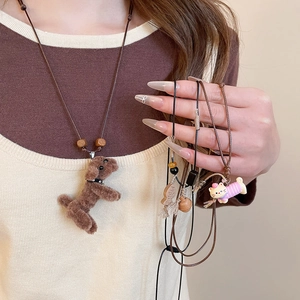 Close-up of cute plush puppy and kitten pendant necklace with wooden beads and cords