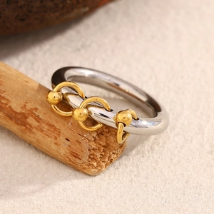 Detail of 18K gold-plated beaded tassels and interlocking rings on a stainless band