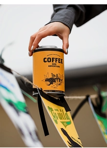 Detail of yellow airtight coffee tin with panther illustration for outdoor camping storage