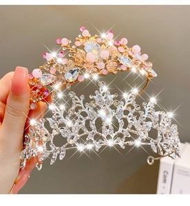 Close-up of gold and silver princess crowns with pink beads and sparkling crystals