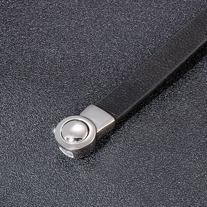 Macro detail of braided black leather strap with polished silver stainless steel clasp