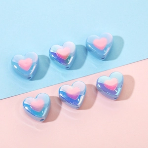 Macro view of gradient heart beads with iridescent finish for DIY jewelry crafts