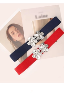 Detail of navy blue and red elastic waist belts with silver double flower metal buckles