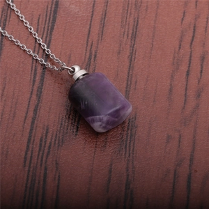 Macro view of purple amethyst perfume bottle pendant on silver stainless steel chain