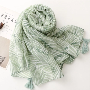 Detail of tropical green palm leaf scarf with fringe tassels and soft breathable fabric