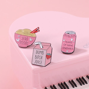 Pink enamel pin set with funny strawberry milk and noodles designs on a piano