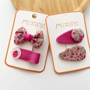 Detailed set of handmade pink floral bow hair clips with strawberry accents for girls