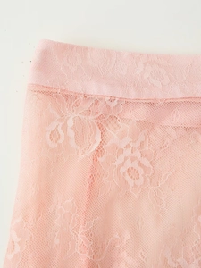 Detailed close-up of pink floral lace fabric and elastic waistband on a skirt