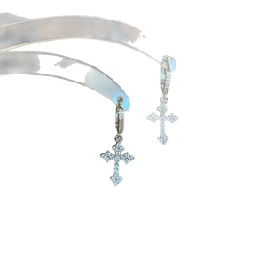 Minimalist silver cross drop earrings with sparkling cubic zirconia on a curved stand