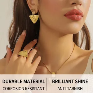 Detail of gold triangle jewelry set showing hammered texture on model