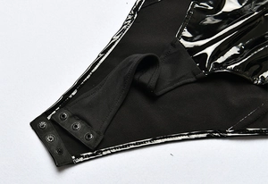Detail view of the black bodysuit crotch with snap button closure and mixed fabrics