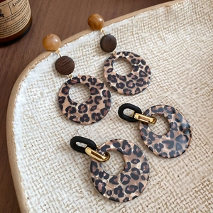 Macro detail of leopard print acrylic earrings with vintage resin and wood elements